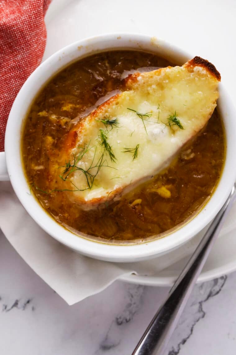 Classic French Onion Soup topped with melted Gruyere cheese and toasted baguette